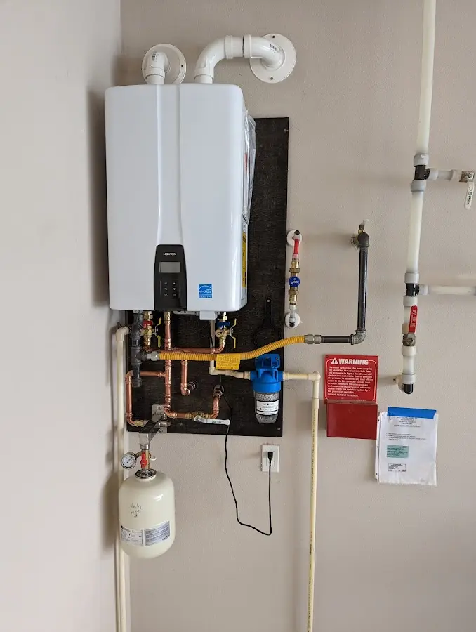 Professional plumber installing copper piping in a Plainfield home